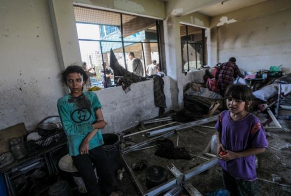 epa11478359 An injured Palestinian girl (L) stands among debris in a damaged UNRWA school following an Israeli air strike in Al Nuseirat refugee camp, central Gaza Strip, 14 July 2024. At least 12 people were killed following an Israeli air strike in the camp, according to the Palestinian Ministry of Health. The Israeli military stated on 14 July, that the Israeli Air Force (IAF) struck the area of UNRWA's Abu Oraiban School School building in Nuseirat, claiming that the location served as a 'hideout and operatio<em></em>nal infrastructure' to direct and carry attacks against Israeli troops operating in the Gaza Strip. More than 38,000 Palestinians and over 1,400 Israelis have been killed, according to the Palestinian Health Ministry and the Israel Defense Forces (IDF), since Hamas militants launched an attack against Israel from the Gaza Strip on 07 October 2023, and the Israeli operations in Gaza and the West Bank which followed it. EPA-EFE/MOHAMMED SABER