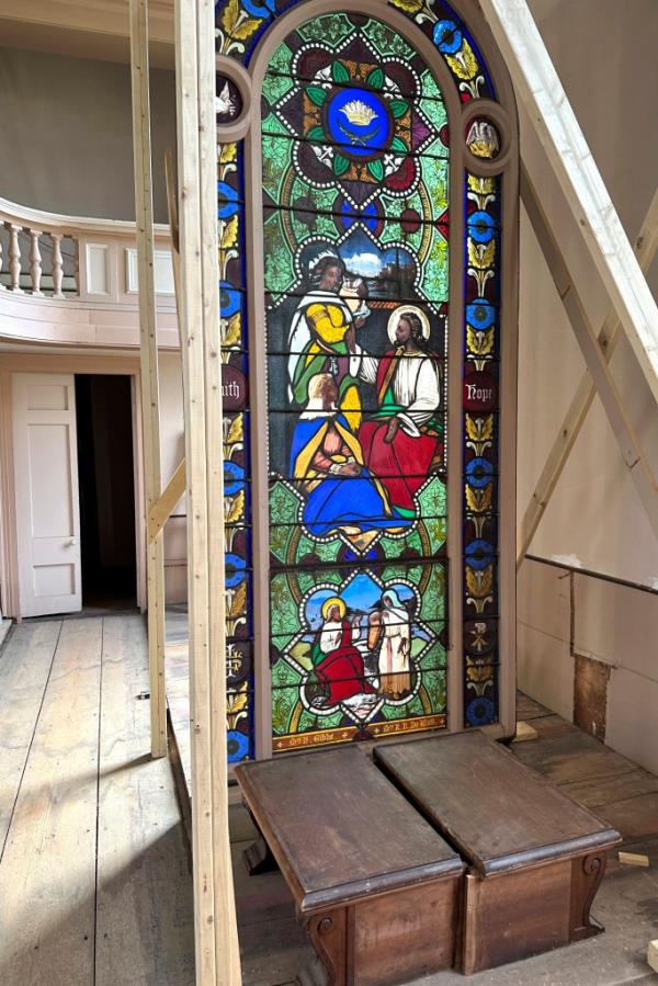 Stained glass that depicts Christ and three New Testament women with dark skin.