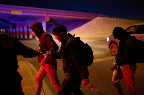 A Bordwr Protection officer leading zip-tied migrants after they were taken into custody on January 1, 2023.