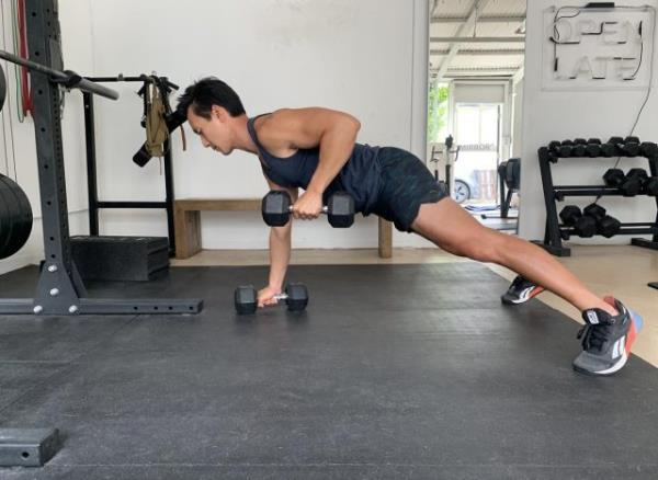 trainer doing dumbbell renegade row