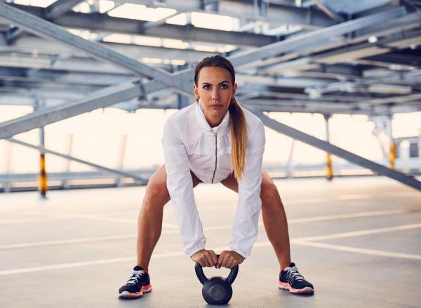 woman performing kettlebell swing to shrink visceral fat