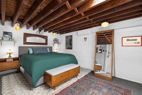 A bedroom with beamed ceilings.