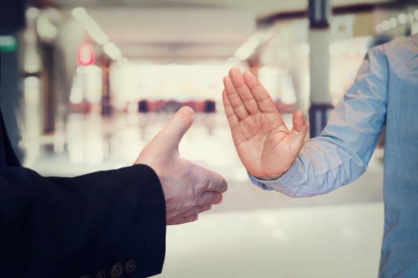 man refusing hand shake with her friend to protect herself from coro<em></em>navirus in public areas. Prevention of fight against pandemic. Non-co<em></em>ntact greeting. Quarantine methods to co<em></em>ntrol spread of virus.