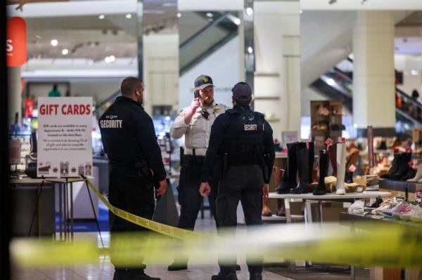 Security officers speak inside a store at the Mall of America in Bloomington, Minn., after reports of shots fired on Friday, Dec. 23, 2022.