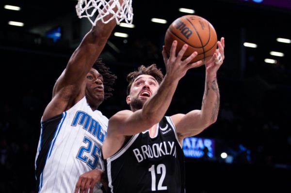 Brooklyn Nets forward Joe Harris (12) shoots in front of Orlando Magic forward Admiral Schofield (25)