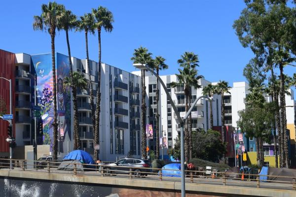 Tents belo<em></em>nging to homeless people are seen by new highrise developments alo<em></em>ngside a freway ramp in Los Angeles 