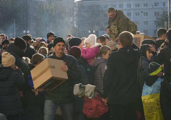 People receive humanitarian aid on central square in Kherson, Ukraine, Tuesday, Nov. 15, 2022. 