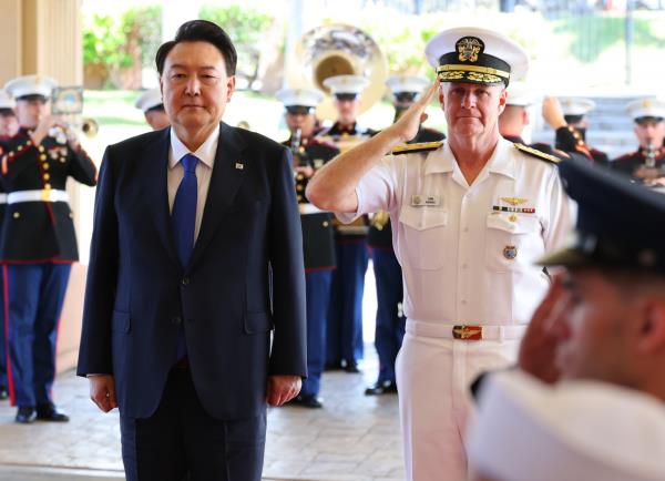 President Yoon Suk Yeol (left) and Adm. Samuel Paparo, commander of the Indo-Pacific Command, salute their countries' natio<em></em>nal flags during Yoon's visit to Camp Smith, the command's headquarters in Hawaii, on Tuesday. (Yonhap)