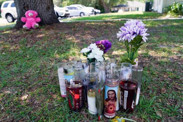 A small memorial is seen outside an apartment,