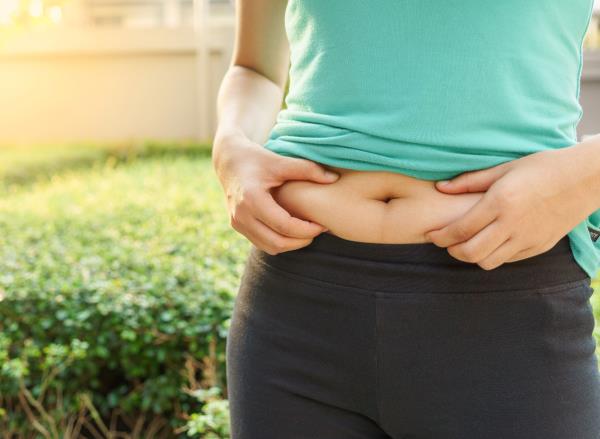 woman holding belly fat, co<em></em>ncept of belly fat-melting tips