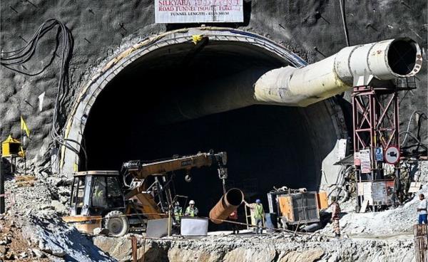 rescue perso<em></em>nnel manoeuvre a me<em></em>tal tube through an entrance of the under co<em></em>nstruction road tunnel, days after it collapsed in the Uttarkashi district of India's Uttarakhand state on November 21, 2023. Forty-one Indian workers trapped in a collapsed road tunnel for 10 days were seen alive on camera on November 21, for the first time, looking exhausted and anxious, as rescuers attempted to create new passageways to free them. (