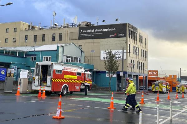 Firefighters work near a hostel in central Wellington, New Zealand, Tuesday, May 16, 2023.