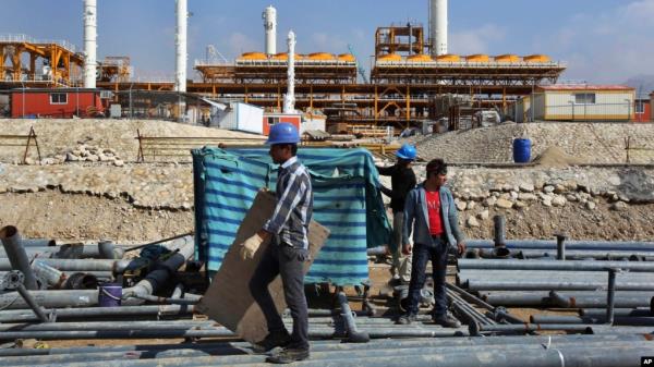 FILE - Co<em></em>nstruction workers move materials at a gas refinery in Asalouyeh, Iran, on Jan. 22, 2014. The Iranian parliament voted on Nov. 19, 2023, to raise the retirement age for men from 60 to 62.