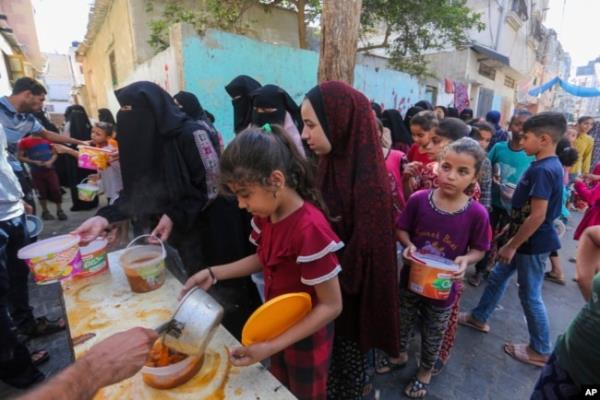 Palestinians receive food in Rafah, southern Gaza Strip, Nov. 8, 2023. Since the start of the Israel-Hamas war, Israel has limited the amount of food and water allowed to enter the territory.