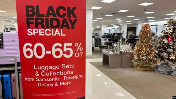 A sign announces Black Friday specials on luggage sets inside a Macy's department store Nov. 20, 2023, in Denver. 