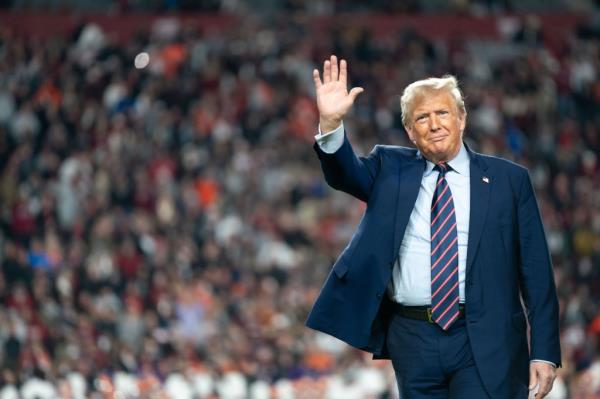 President Do<em></em>nald Trump waves to the crowd on the field during halftime in the Palmetto Bowl between Clemson and South Carolina at Williams Brice Stadium on November 25, 2023 in Columbia, South Carolina.