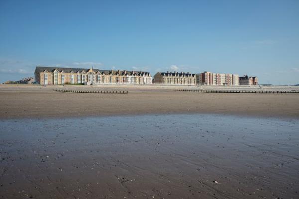 A view of Rhyl beach and a line of buildings looking out to it