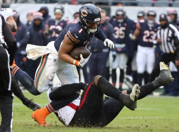 Bears quarterback Justin Fields escapes the Falcons pass rush and runs for a first down in the third quarter on Dec. 31, 2023, at Soldier Field. 