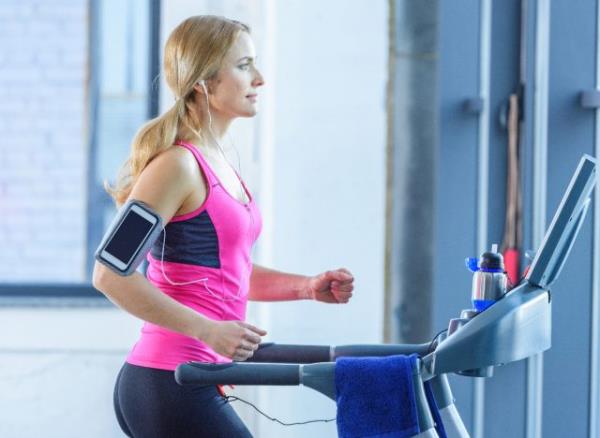 fit blo<em></em>nde woman doing treadmill incline walking workout