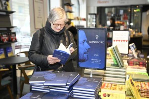 A woman reads a copy of 'Kongeord' (The Word of a King), the book written by Jens Andersen a<em></em>bout King Frederick X, at a bookstore in Copenhagen on January 17, 2024. 