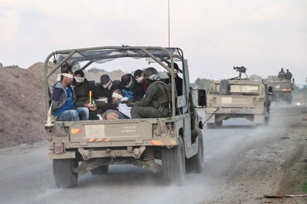 Israeli forces are seen above transporting Palestinian detainees from the Gaza Strip on Monday.