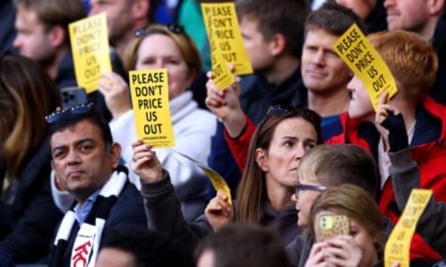 Fans of Fulham hold flyers reading “Please don’t price us out” during the Premier League match between Fulham and Manchester United.