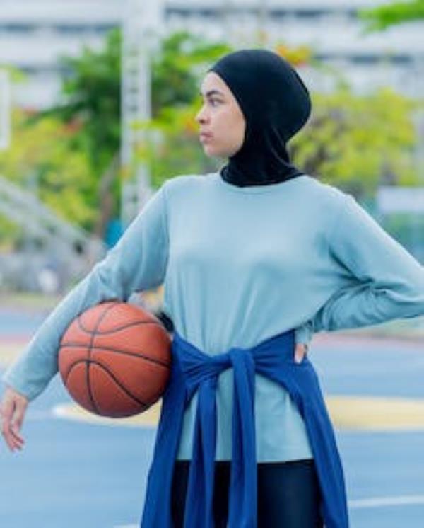 A youth seen with a baskeball and an empty court.