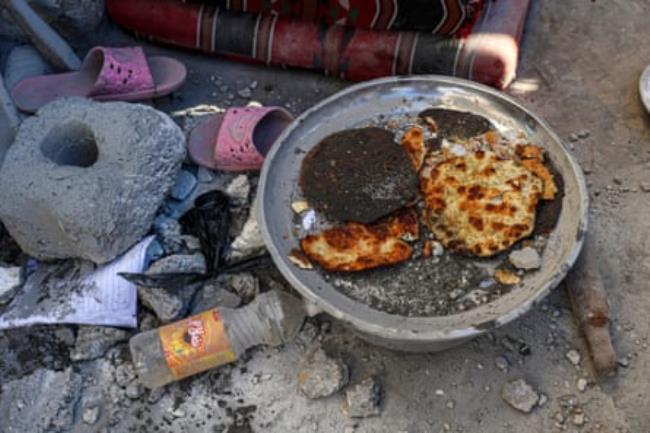 Bread is prepared on a makeshift stove in a damaged house in Rafah.