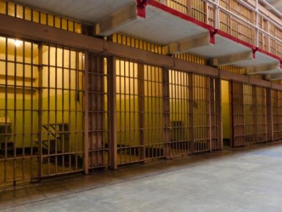 Woman reading Bible in prison cell