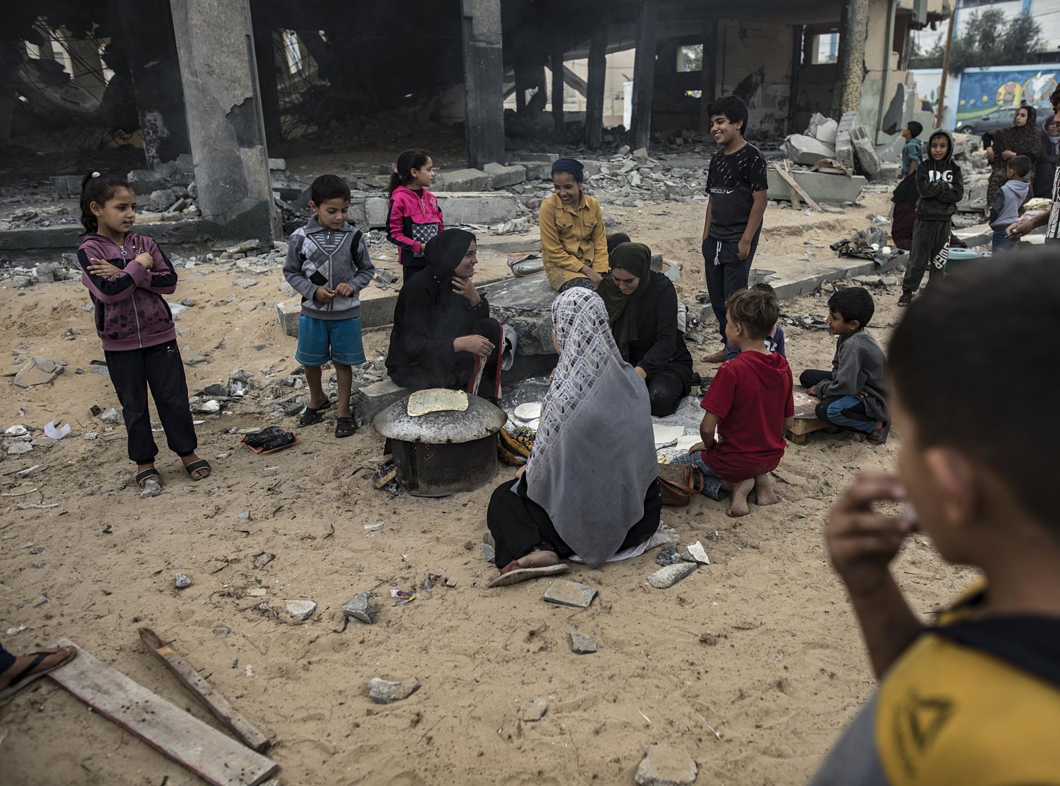 Displaced Palestinians prepare bread near the rubble of a destroyed building in Khan Yunis, southern Gaza Strip, Palestine, Nov. 13, 2023.