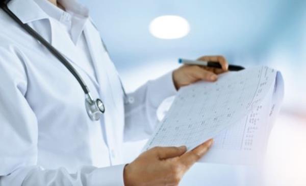 Woman doctor checking out and reading final reports in the room of a hospital background