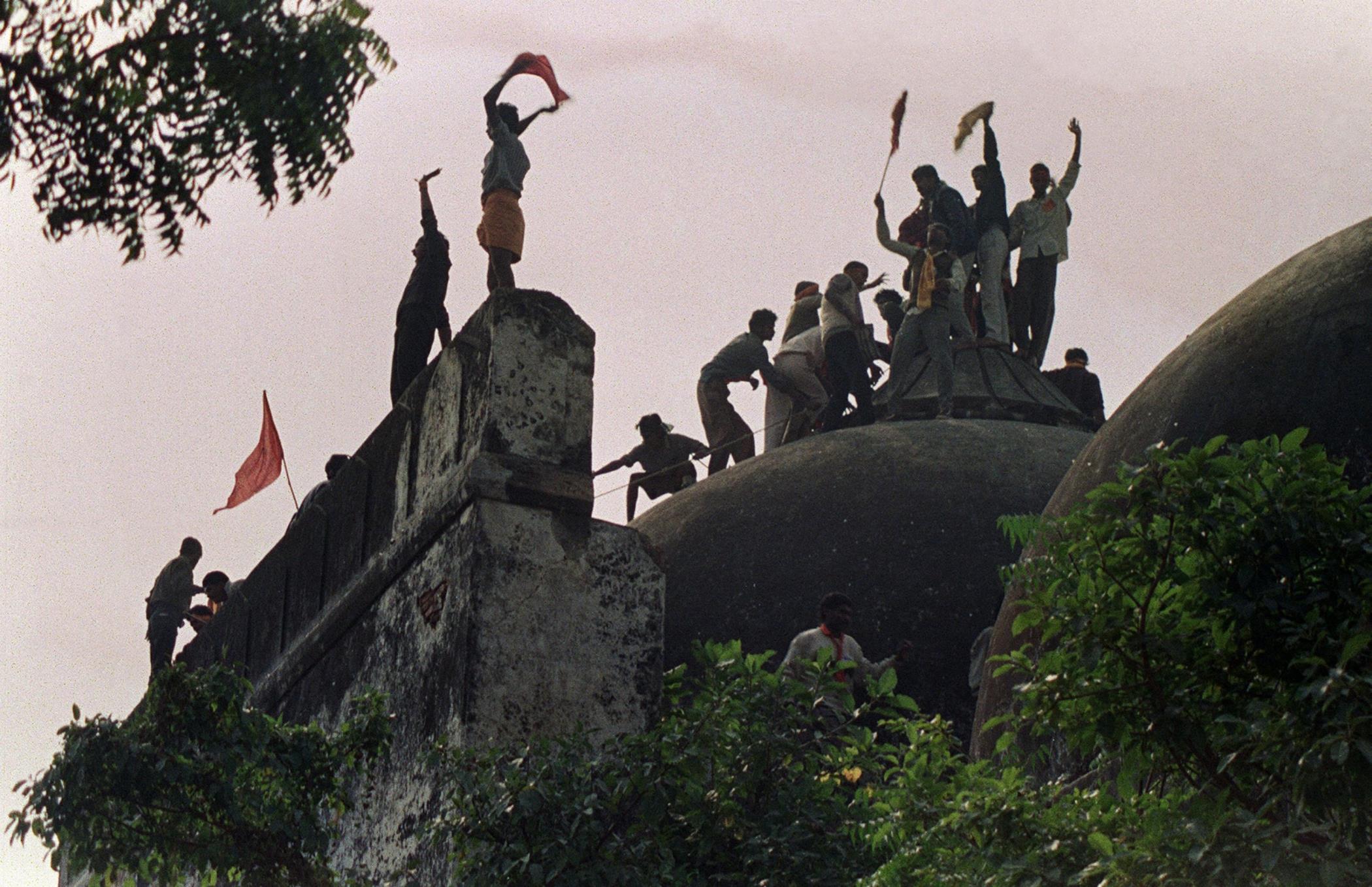 Hindu zealots shout and wave banners atop the 16th Century Babri Mosque, Ayodhya, India, Dec. 6, 1992. (AFP Photo)