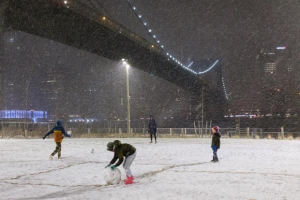 Snow falls in Brooklyn Bridge Park in Brooklyn, New York City on Sunday, January 16, 2022. (Gardiner Anderson for New York Daily News)