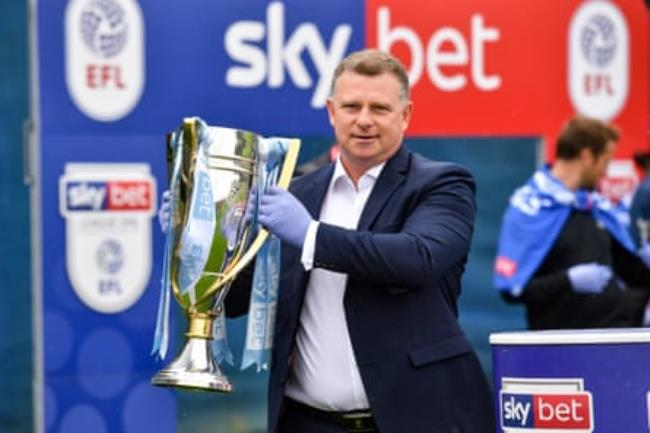 Coventry’s manager Mark Robins lifts the League One trophy at the club’s Ryton training ground in June 2020.