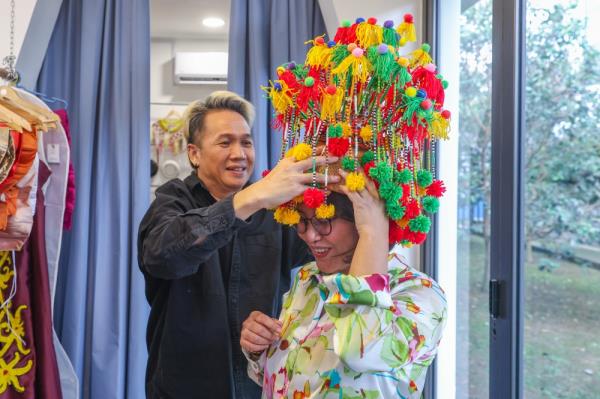 Fashion designer Gilbert Francis Untam helps Bernama reporter Lucia Terey John wear Dujung Manik, a type of traditio<em></em>nal jewellery of the Iban people of Batang Rajang in Sarawak at Gilbert Headhunter's clothing boutique @G&Co in Seri Kembangan September 9, 2023. — Bernama pic