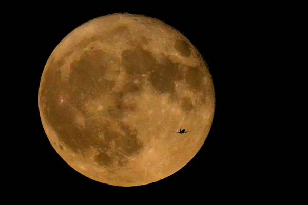 A commercial airliner flies Northwest across Lake Michigan in front of the 