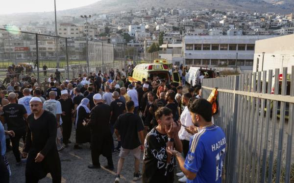 Israeli emergency services and local residents gather near a soccer field wher<em></em>e a rocket hit in Majdal Shams.