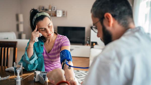 A young woman checks her blood pressure.