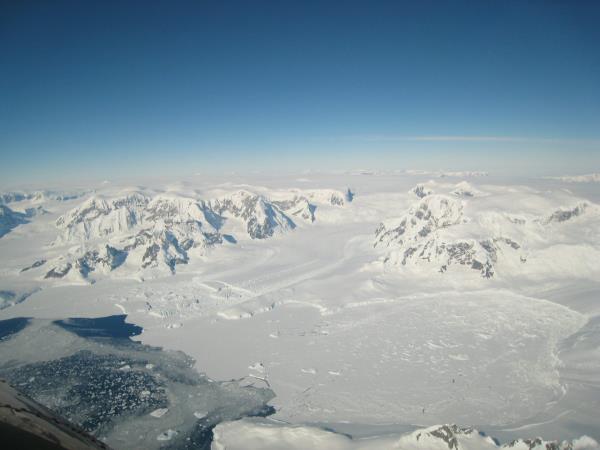 Ice on the Antarctic peninsula flowing along a channel into an ice shelf in the ocean.