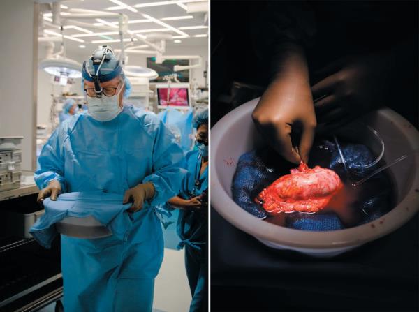 Medical worker exiting operating room carting a co<em></em>ntainer in two hands.