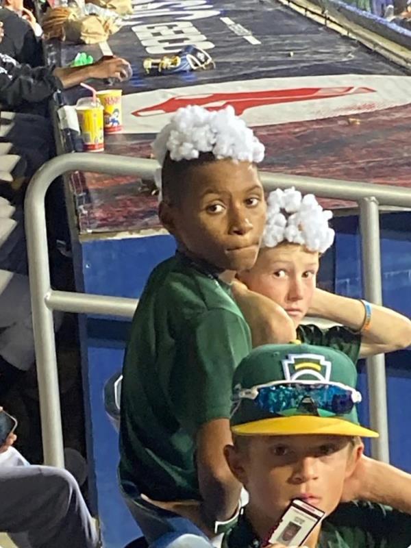 The two teammates from the Iowa team  with cotton in their hair to ho<em></em>nor a player who had a white mohwak.