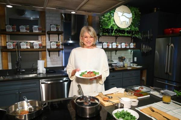 Martha Stewart prepares food in the kitchen.