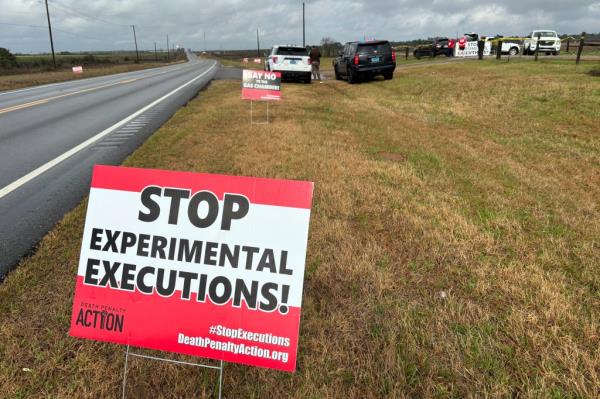 Anti-death penalty activists place signs along the road heading to Holman Correctio<em></em>nal Facility 