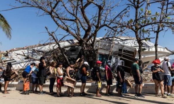 People affected by the passage of Hurricane Otis line up to receive aid 