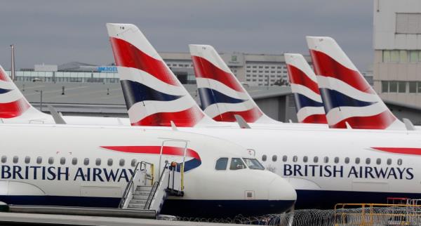 FILE - British Airways planes parked at Heathrow Airport's Terminal 5 in London, Wednesday, March 18, 2020. Mixed signals are emerging a<em></em>bout travel in Europe heading into the winter season. British Airways is cutting more than 10,000 short-haul flights in and out of Heathrow Airport through March 2023, while nearby Gatwick Airport is ending its limits on the number of daily flights. (AP Photo/Frank Augstein, File)