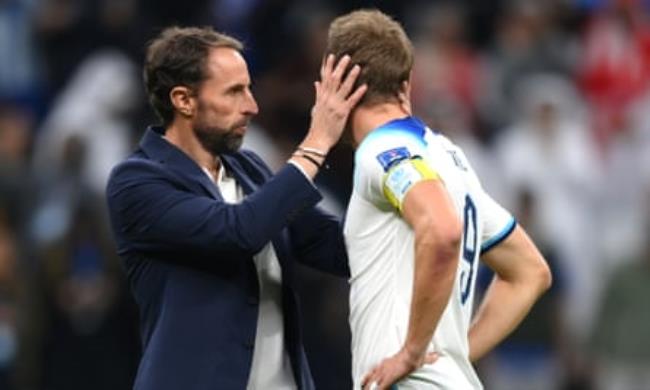 Harry Kane of England is co<em></em>nsoled by Gareth Southgate after losing to France in the 2022 World Cup quarter-final