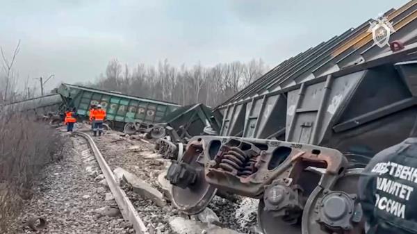 Train carriages lying alo<em></em>ngside the tracks with workers in high-vis jackets standing further down the line