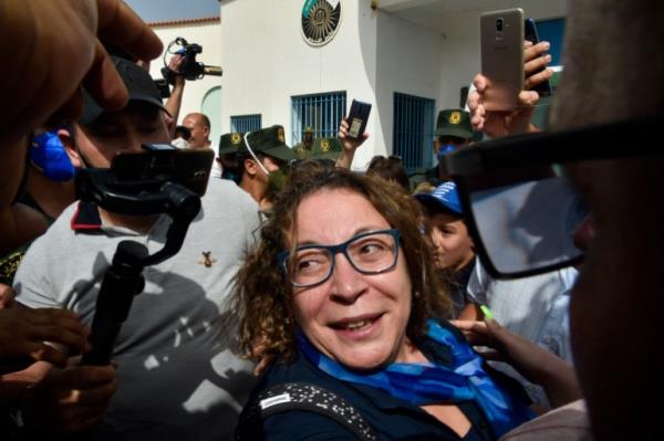 Amira Bouraoui in the middle of a media scrum as she exits the prison