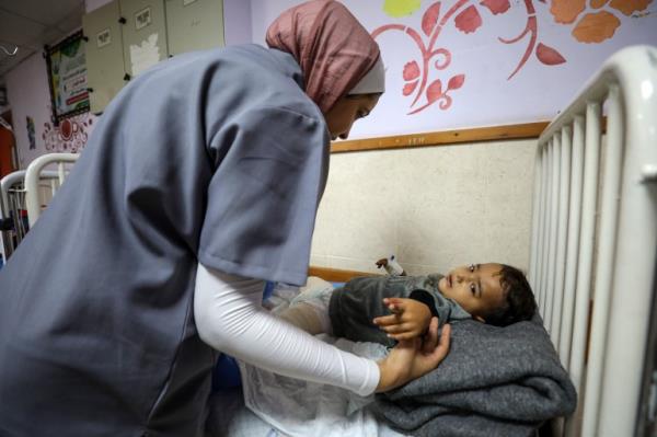 A nurse checks on Ahmad Shabat, whose legs were blown off in an Israeli air attack in Nuseirat refugee camp on November 12 2023 