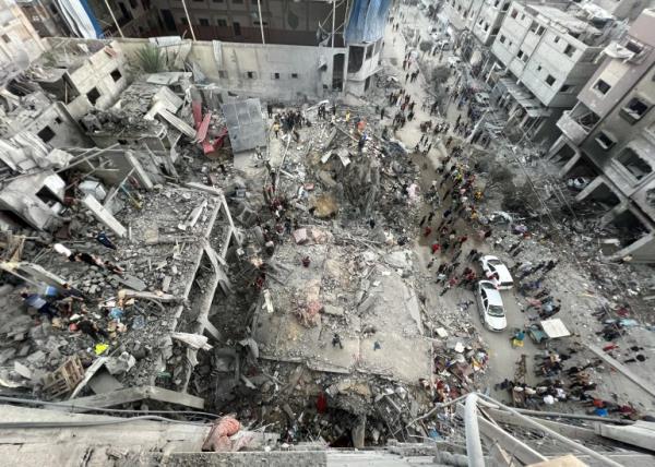 Civil defense teams and civilians co<em></em>nduct a search and rescue operation under the rubble of demolished buildings after Israeli bombardment at Jabalia refugee camp